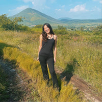 Woman standing on a dirt path with a mountain in the background