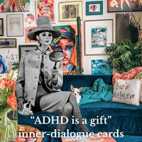 Living room with colorful artwork, a blue couch, and a vintage-style card with text.